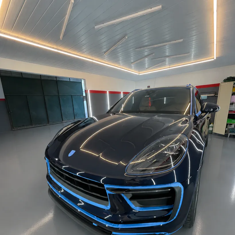 Porsche Macan azul enmascarado con cinta azul antes del sellado
