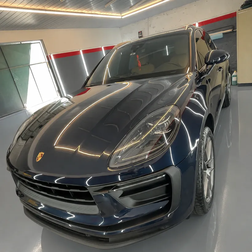Porsche Macan azul de frente en el box
