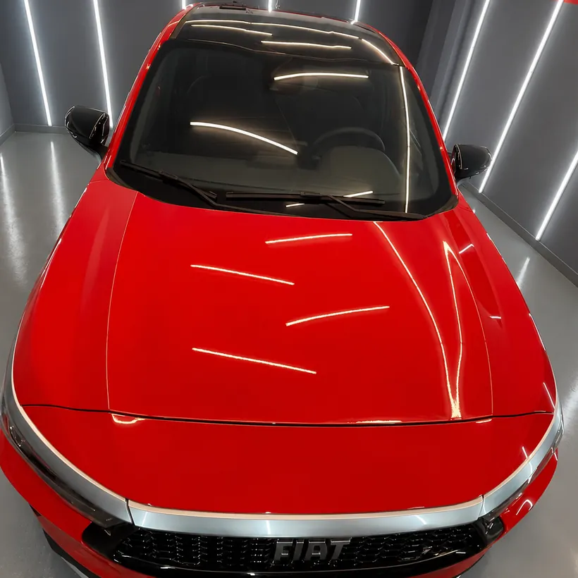 Capo rojo de un Fiat visto desde arriba, con brillo parejo