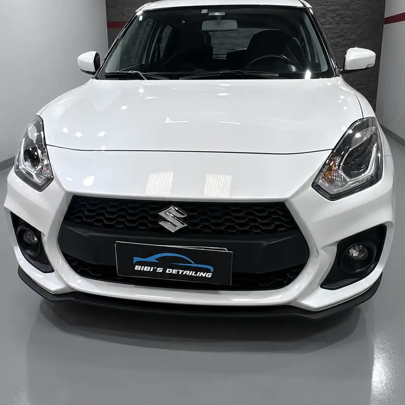 Suzuki Swift blanco de frente con el film de protección colocado
