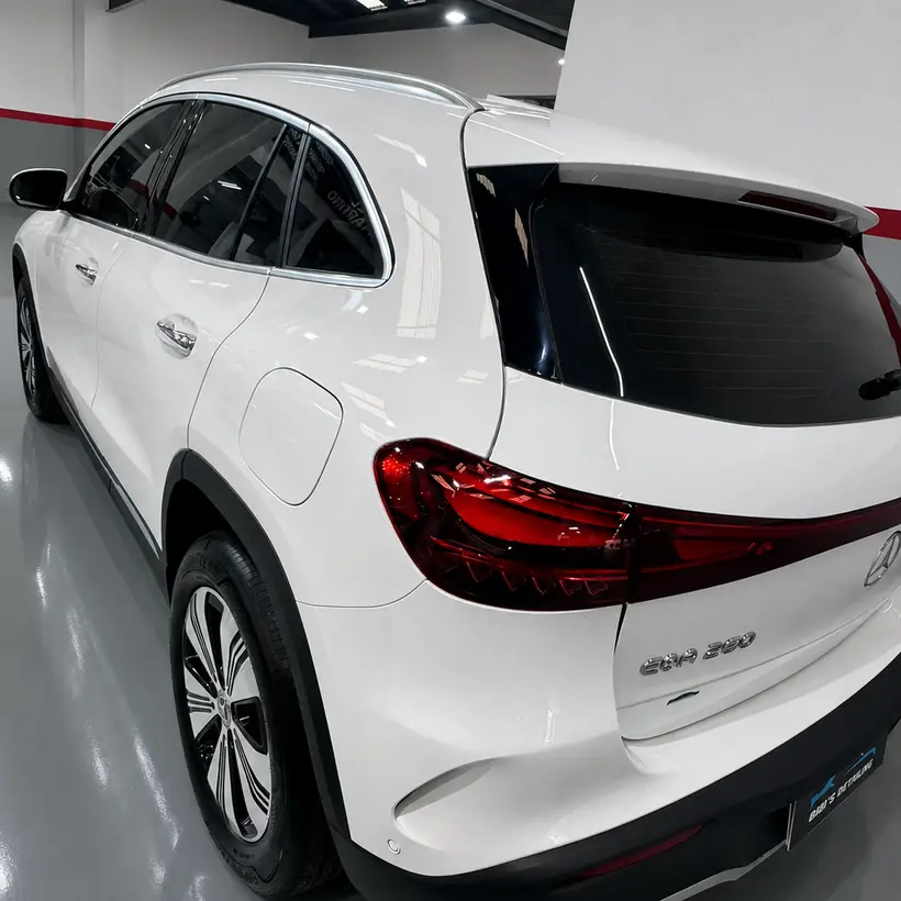 Trasera de un Mercedes EQA blanco con láminas en los vidrios