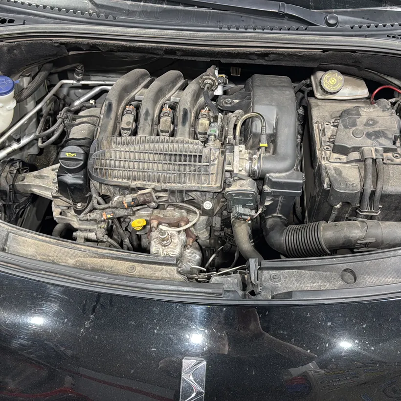 Motor detallado bajo el capó de un auto oscuro