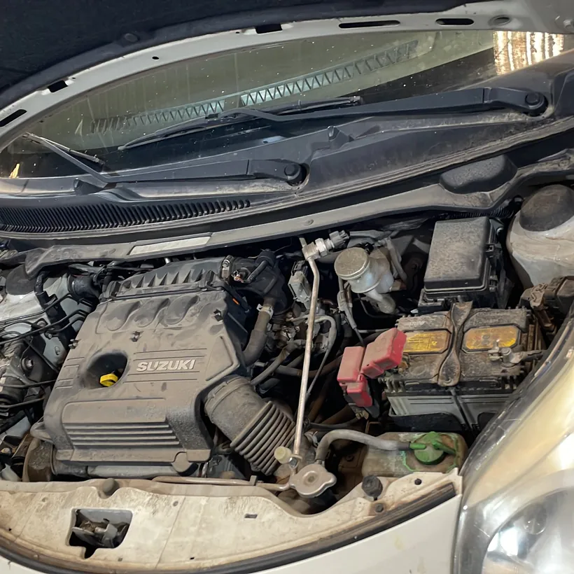Motor Suzuki limpio con el capó abierto en el box
