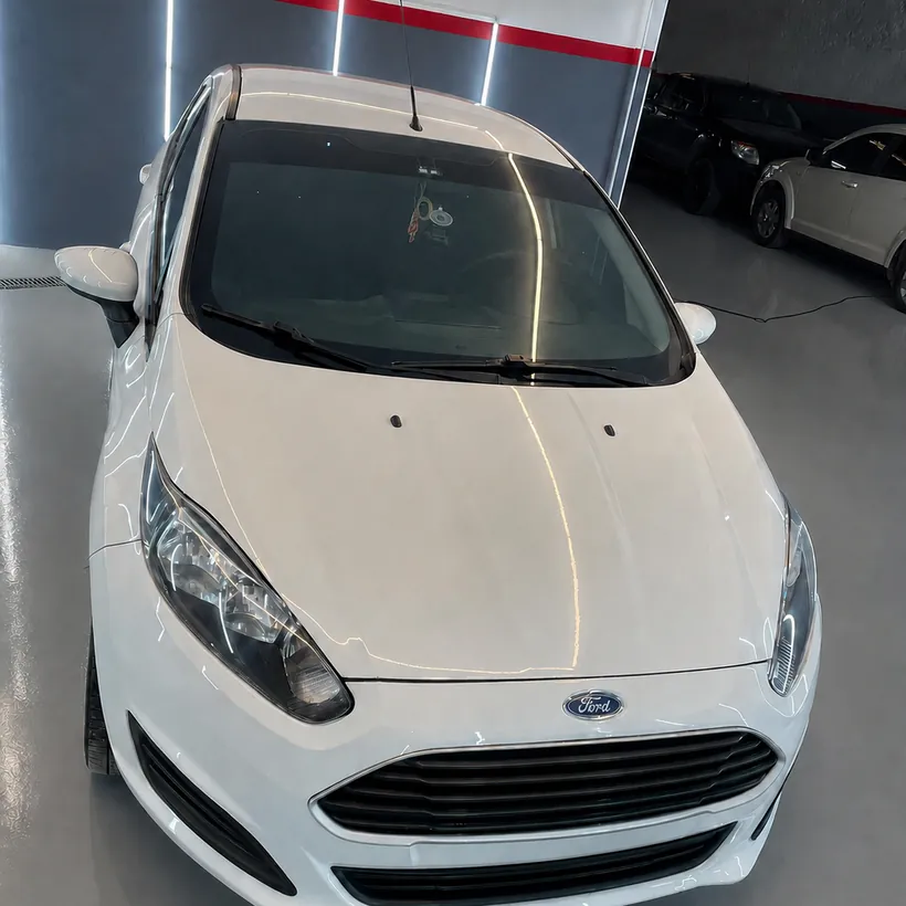 Frente de un Ford Fiesta blanco con la optica y el capo pulidos
