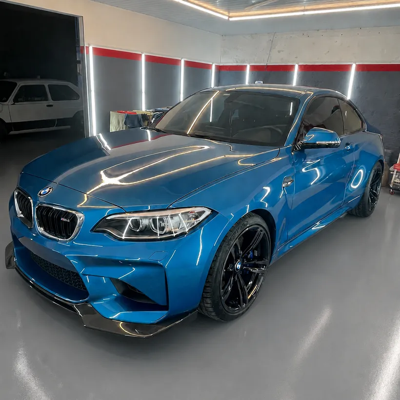 BMW M2 azul de frente, con reflejo limpio sobre el capo