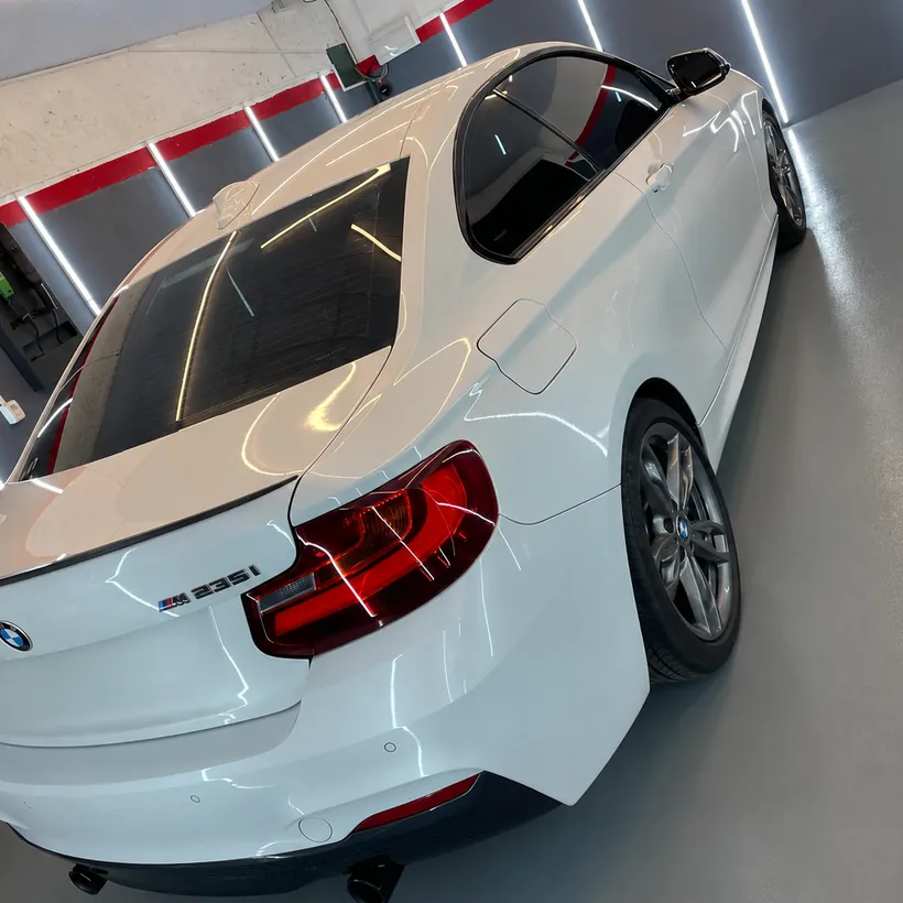 Cola de un BMW Serie 2 blanco con reflejo parejo