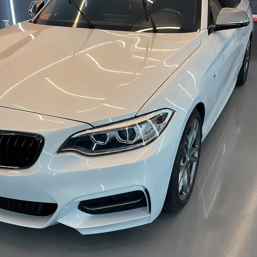 Frente de un BMW Serie 2 blanco despues del trabajo