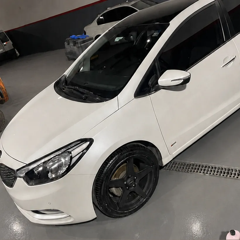 Kia blanco en el box, con la pintura corregida y brillo parejo