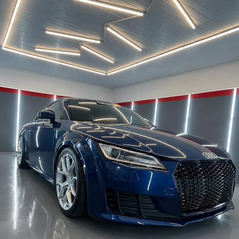 Audi TT azul oscuro de frente en el box