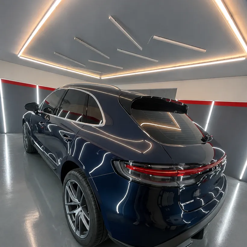 Cola de un auto azul oscuro con reflejo limpio