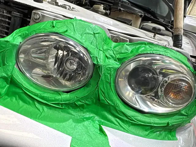 Óptica delantera enmascarada con cinta verde durante el pulido