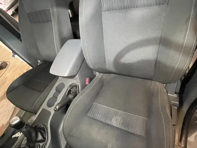 Butaca delantera y consola central de un auto después de la limpieza